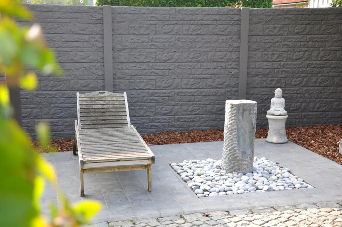 Anthrazitfarbener Betonzaun Motiv Linea an einer Terrasse mit Brunnen