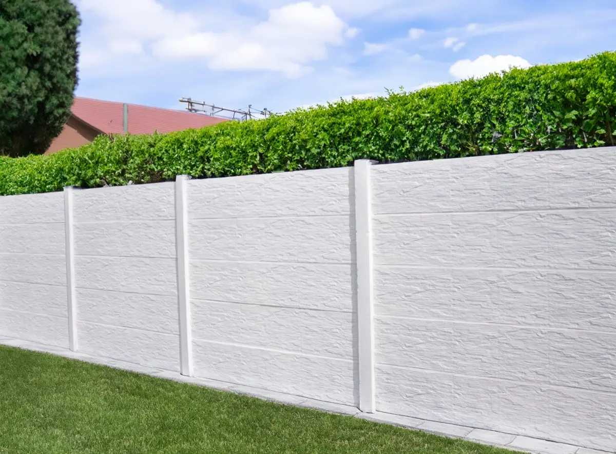 Weißer Betonzaun Motiv Schiefer unter einer grünen Hecke